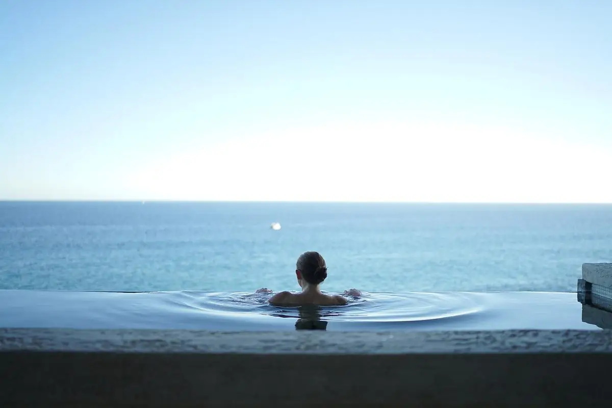 Piscina com borda transparente e vista para o horizonte
